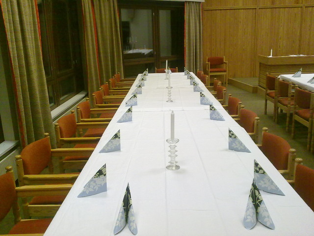 Pitkä juhlapöytä Heinolatalon "valtuustosalissa"