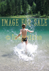 for sale child with water spatters in mountain lake
