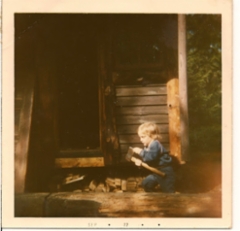 my_son_simo__at_312_learning_to_chop_wood_and_checking_the_ax_for_sharpness_by_the_sauna_house